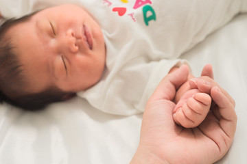 selective focus hand the sleeping baby in the hand of mother clo