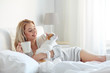 © Syda Productions - happy woman with coffee and cat in bed at home