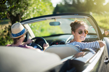 Rear view. Young couple happy to drive his convertible car