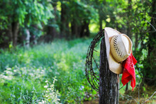 Cowboy Hat With Bandana Hanging On Fence Post