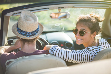 Rear view. Young couple happy to drive his convertible car