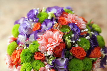 colorful wedding bouquet with golden rings