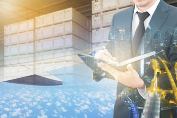 Wall Mural - Double exposure of business man analyzing report and business center city with blurred cargo in wooden case at warehouse and export plane aeriel background, exportation and trading concept