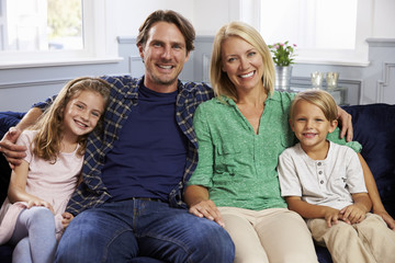 Portrait Of Family Sitting On Sofa Together