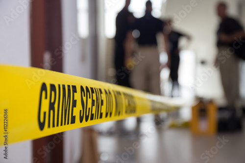 Fotografía crime scene tape in building with blurred forensic team backgrou