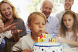 © Monkey Business - Boy Blows Out Birthday Cake Candles At Family Party