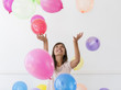 © JGI/Jamie Grill/Blend Images - Mixed race woman playing with balloons
