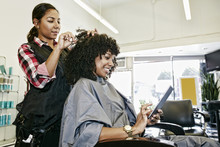 Hairdresser Cutting Hair Of Client In Salon