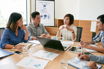 Coworkers discussing strategy of company development in office