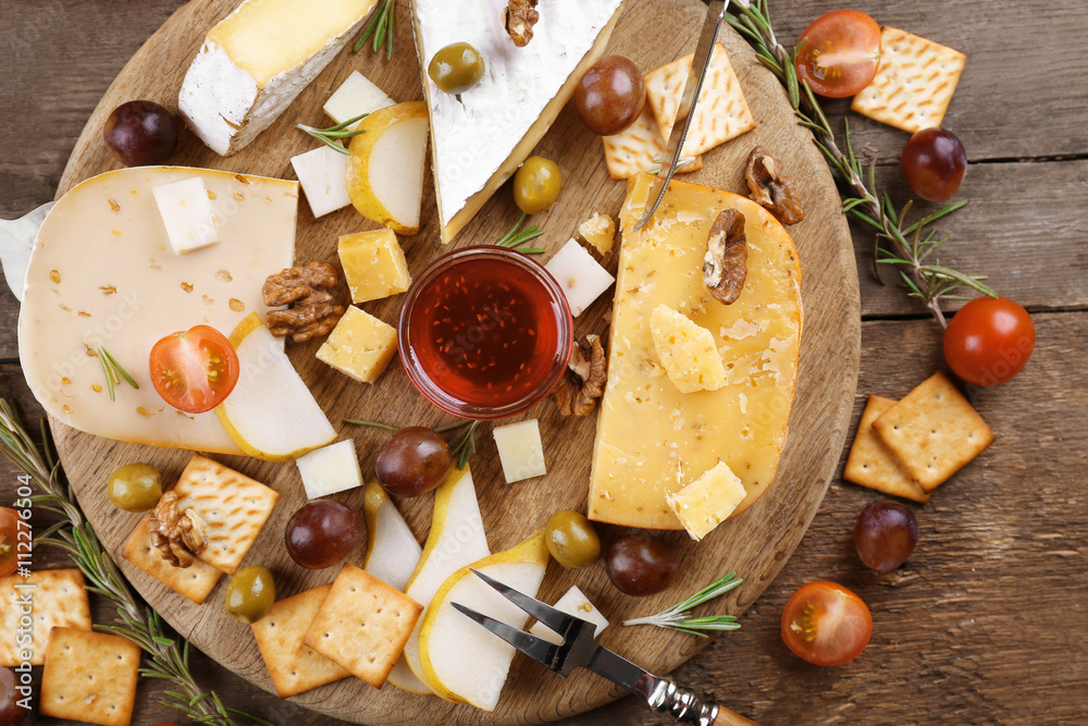 Different kinds of cheese on wooden background