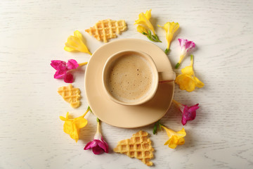 Poster - Cup of coffee with petals and waffles on wooden table