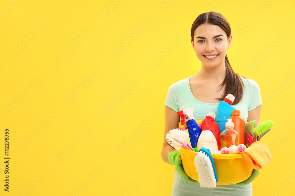 Female cleaner on yellow background