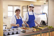 © Monkey Business - Two women waiting to serve lunch in a school cafeteria