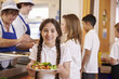 © Monkey Business - Girl with plaits holding plate of food in school cafeteria