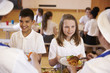 © Monkey Business - Over shoulder view of kids being served in school cafeteria