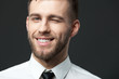 Studio portrait of handsome young businessman smiling and winkin