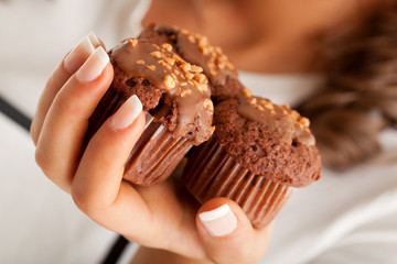 Poster - Three chocolate muffins in hand of a female, close up