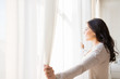 © Syda Productions - close up of woman opening window curtains