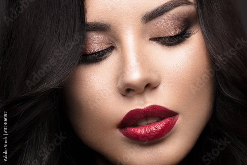 Beautiful brunette model: curls, classic makeup and red lips Plakat