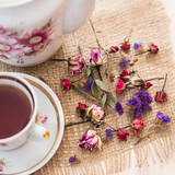Fototapeta Lawenda - Vintage cup of tea with buds of roses