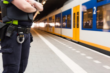 Police Officer Guarding A Train Station To Prevent Terrorist Attacks.