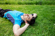 © nickshot - Sport fitness man relaxing listening to music after training outdoor in a city park . Young male athlete resting relaxing lying on grass after running and training exercise outside in summer.