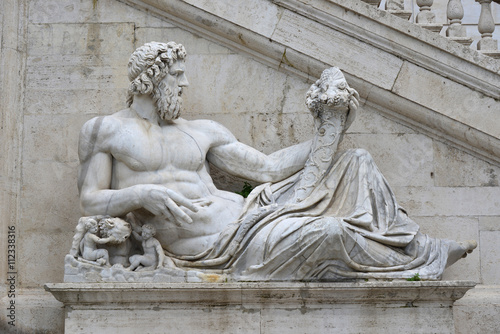 Fotografia Ancient marble statue of River Tiber god protects Romulus and Remus with his rig