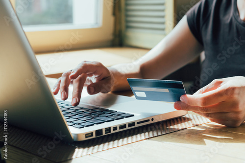 Fotografía girl makes a purchase on the Internet on the computer with credit card