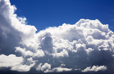 Thick fluffy clouds high in the sky, the landscape. Scenic dense clouds illuminated by the sun during a strong wind.