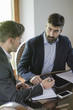 © GENETTICA - Business meeting. A young man with a beard is listening to his c