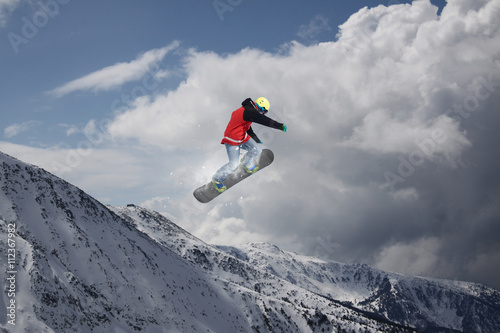 Cuadros en Lienzo Corredor de snowboard que salta sobre las montañas