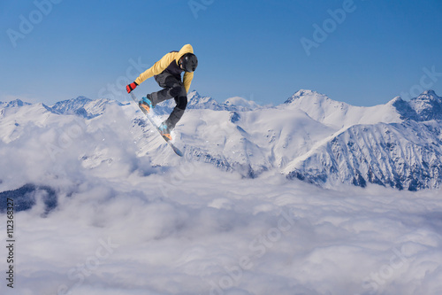 Fotografía Corredor de snowboard que salta sobre las montañas