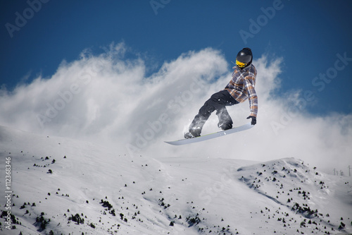 Cuadros en Lienzo Corredor de snowboard que salta sobre las montañas