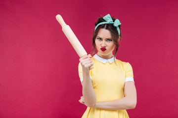 Canvas Print - Mad irritated young woman in yellow dress with rolling pin