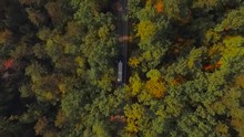 AERIAL VIEW. Bus ride through the woods. Bus passes through the woods. Bus travel. Serbia. Aerial view of the woods and the bus ride. Aerial view of the bus driving