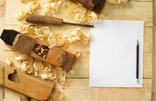 Fotografie, Obraz White sheet on wooden table for carpenter tools with sawdust.