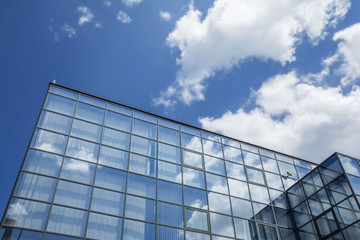 Canvas Print - Building facade with blue sky and white clouds