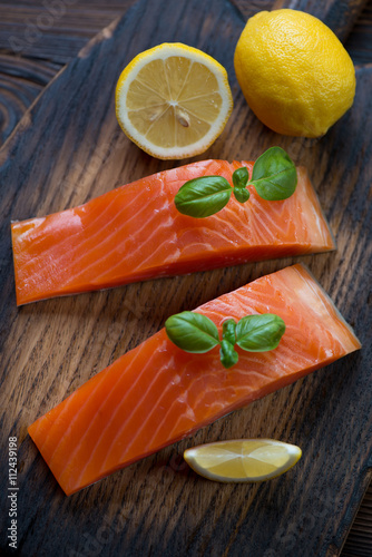 Fotografering Close-up of smoked trout fillet with lemon and basil, above view