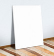 Blank white paper poster on white wall and wooden floor,Mock up