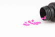Pink drug tablets in bottles