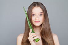 Woman With Clear Skin And Long Healthy Hair Holding Green Aloe L