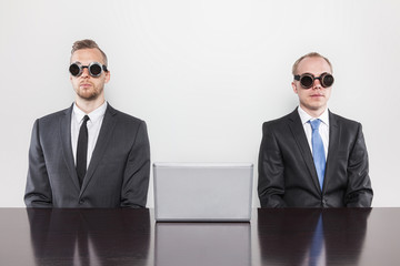 Two vintage businessman sitting at office desk