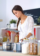 © lenets_tan - Young woman using a tablet computer to cook in her kitchen