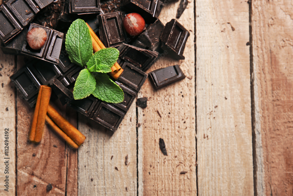 Chocolate pieces with mint leaves on wooden background