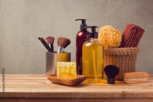 Fotografía Body care products on wooden table over gray background