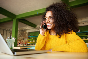 Wall Mural - Happy young woman in cafe making phone call