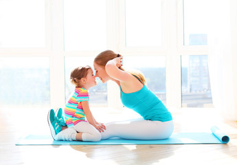 family mother and child daughter are engaged in fitness, yoga at