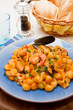 blue dish with gnocchi ,seafood and tomatoes sauce