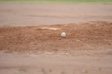 Baseball Sitting On The Pitching Mound Dirt.