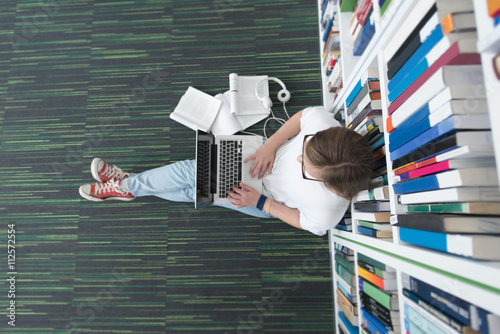 Fotografie, Obraz female student study in library, using tablet and searching for